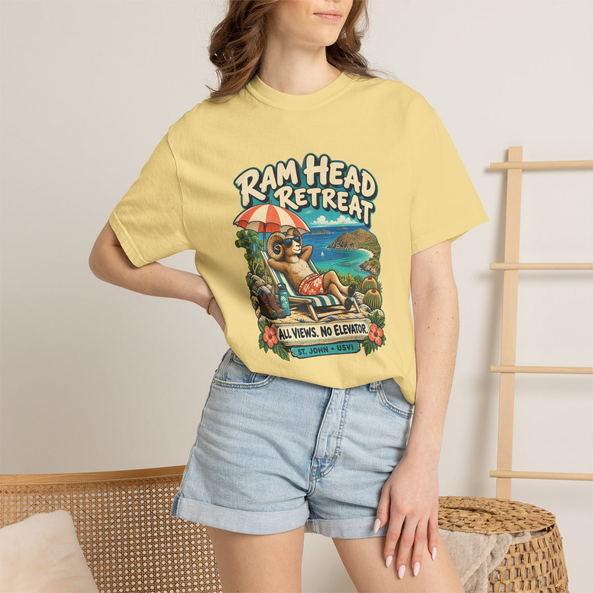 Model wearing a Comfort Colors 1717 T-shirt with the Ram Head Retreat lounging ram illustration and St. John USVI lettering.