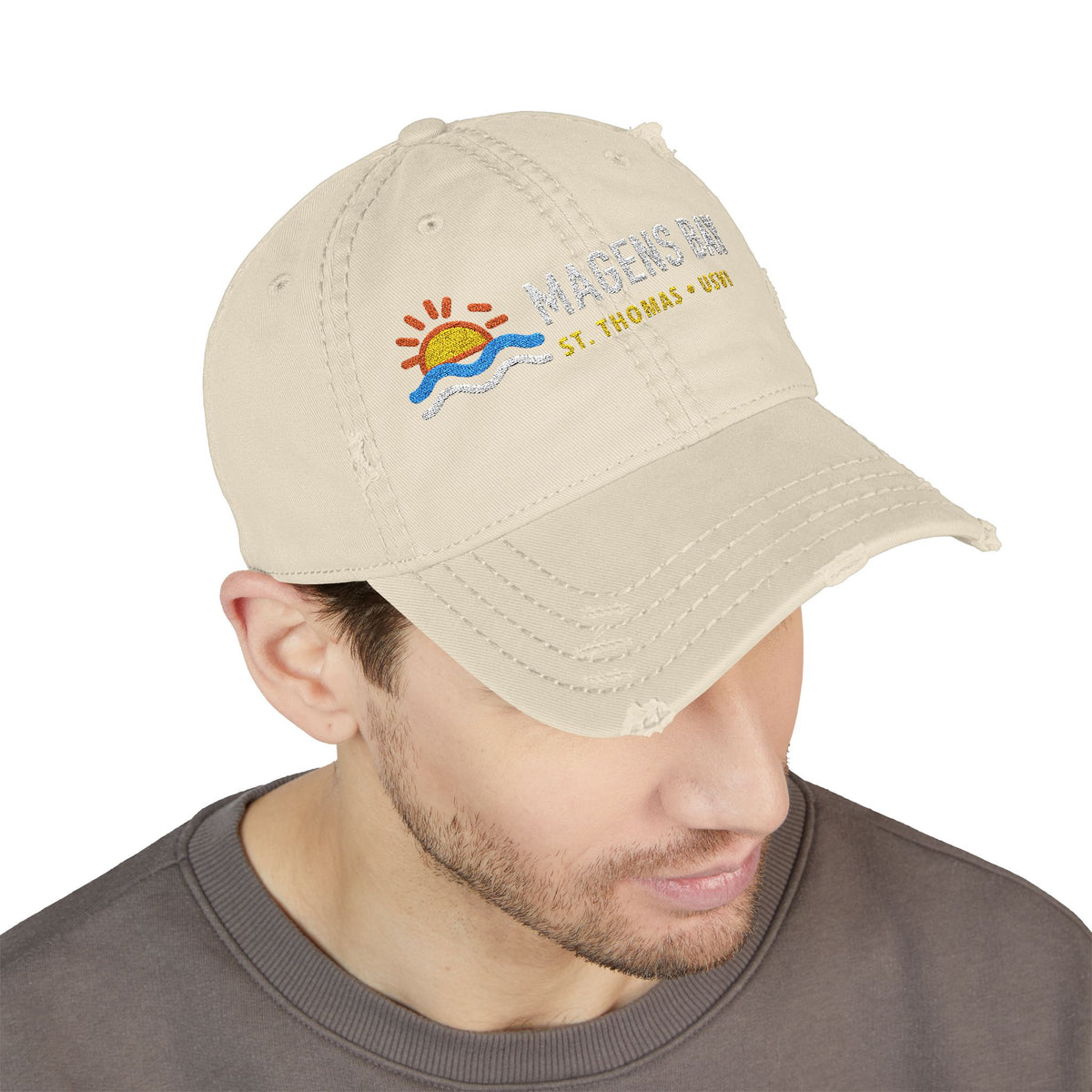 Distressed beige baseball cap with Magens Bay, St. Thomas embroidery.