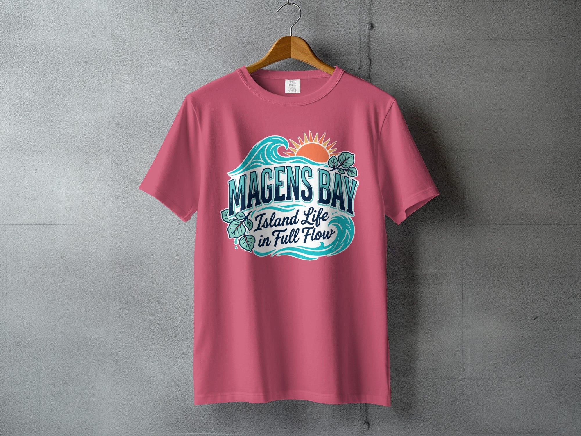 Pink t-shirt with Magens Bay Island Life graphic featuring waves and sun.
