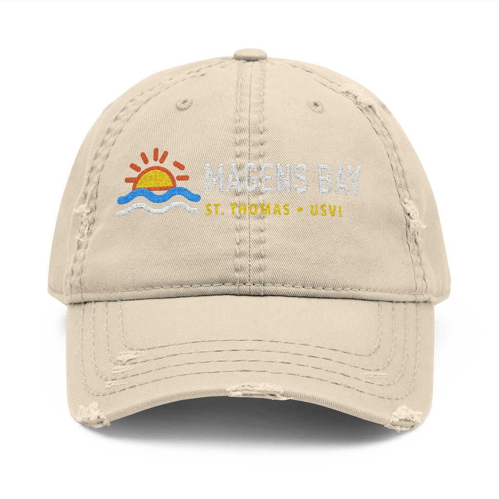 Distressed beige baseball cap with Magens Bay, St. Thomas - USVI embroidered text and sun/wave logo.