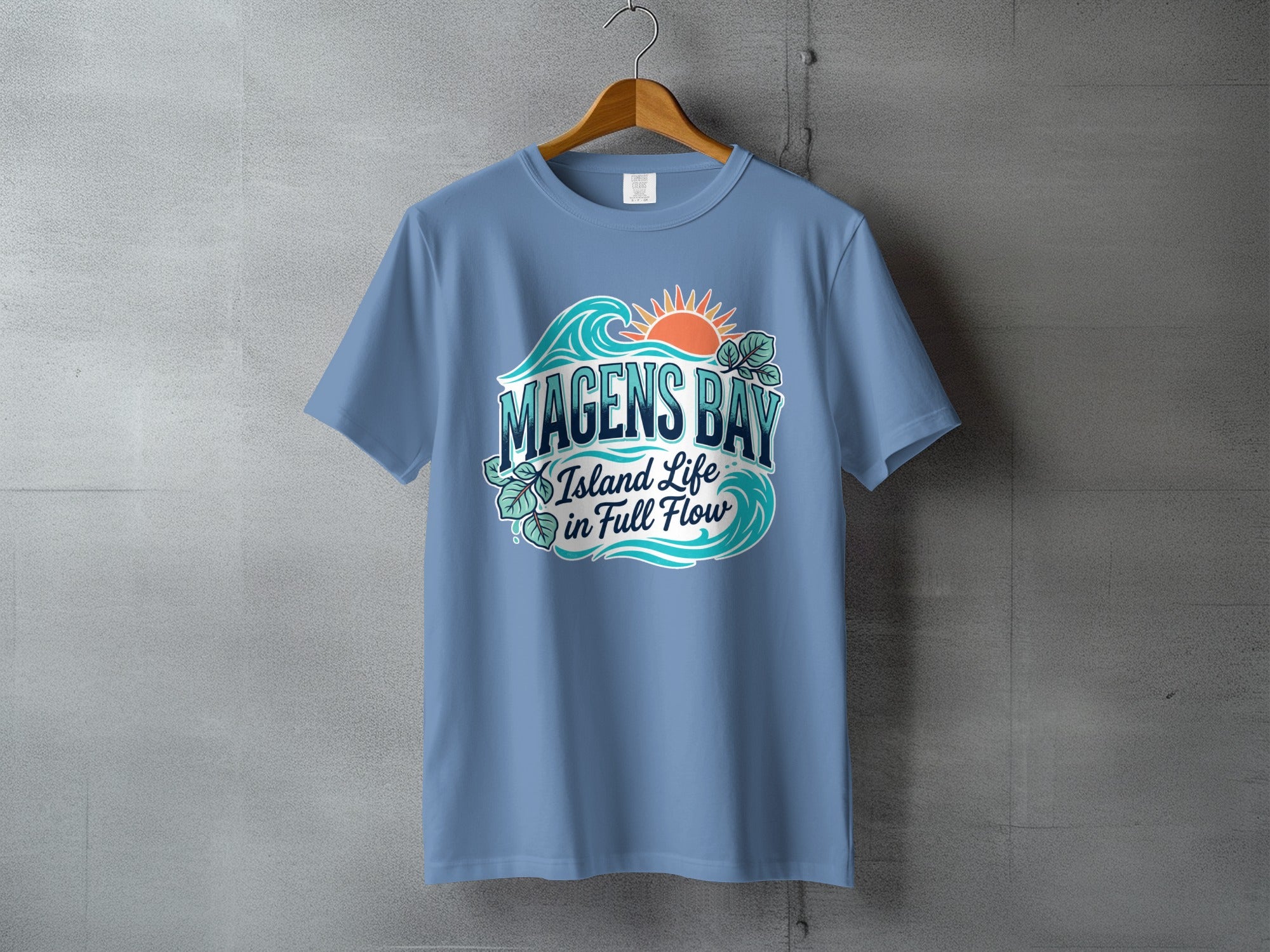Blue t-shirt with "Magens Bay Island Life in Full Flow" text and wave graphics.