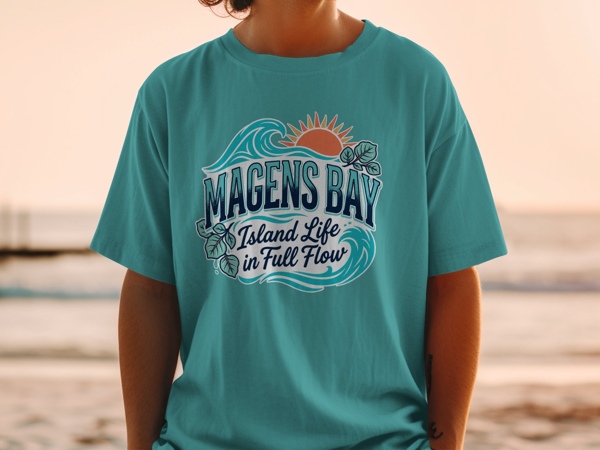 Teal t-shirt with Magens Bay Island Life in Full Flow and ocean wave graphics.
